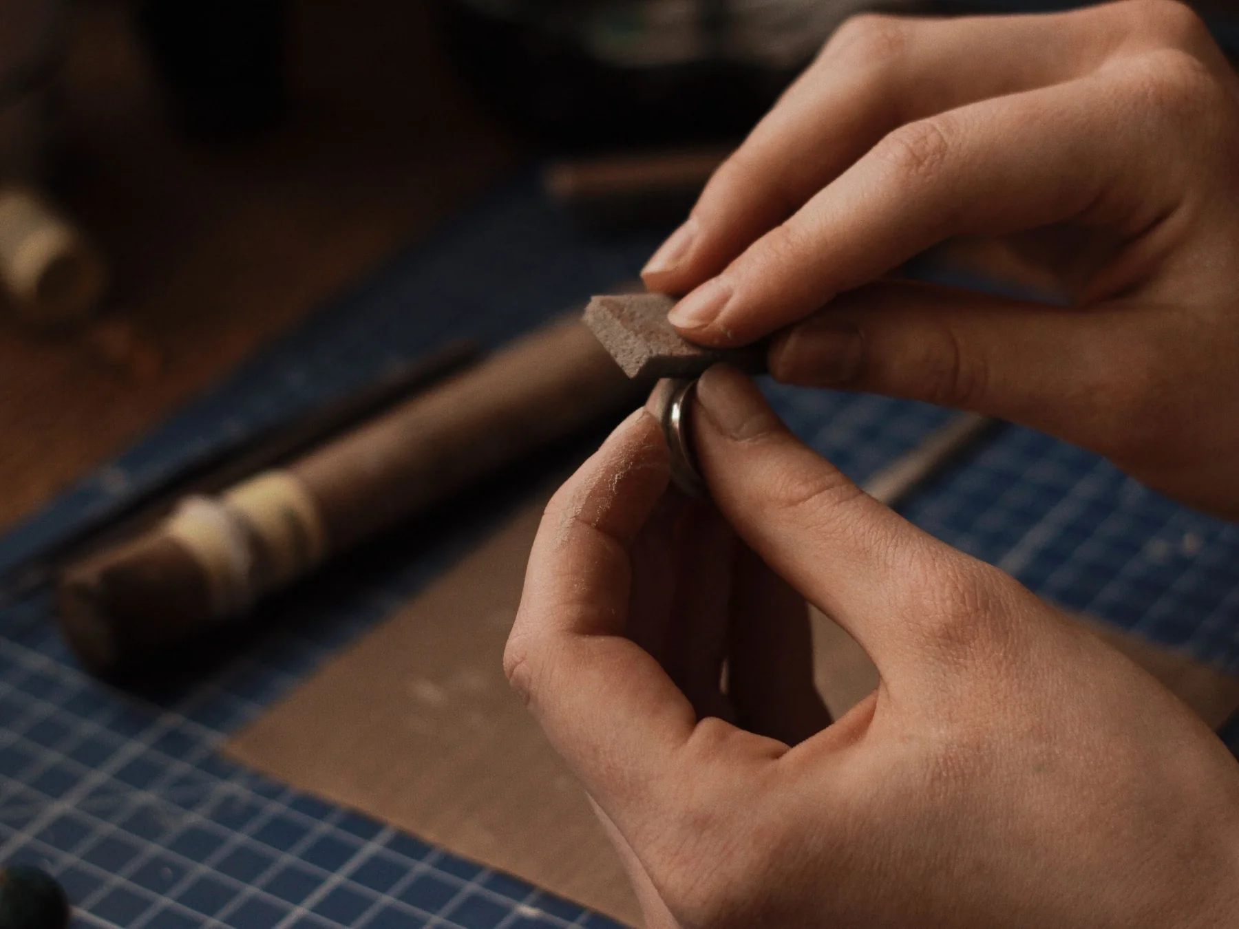 A jeweler polishing a ring at the workbench