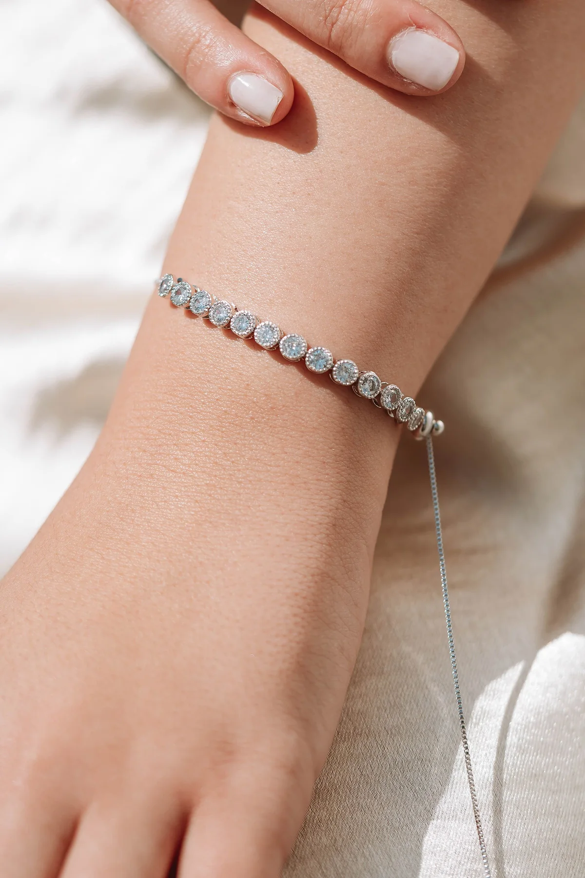 Bezel-set diamond tennis bracelet on a woman's wrist