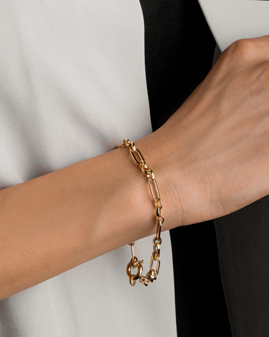 Gold paperclip chain bracelet on a wrist