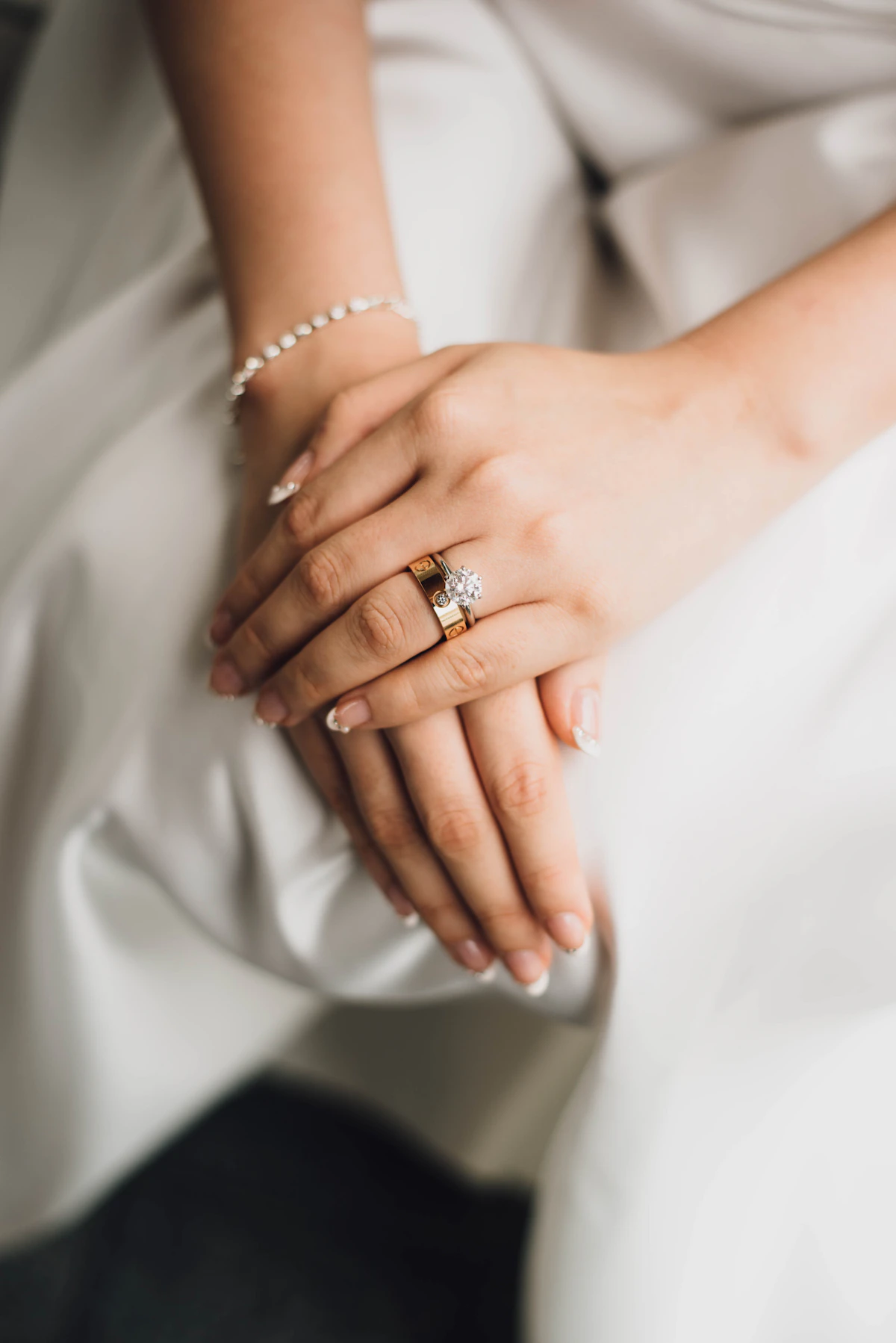 Hands wearing stacked diamond and gold rings