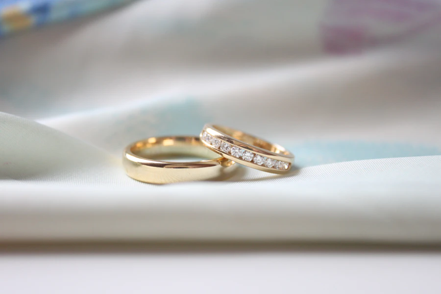 Gold and diamond wedding bands on white silk