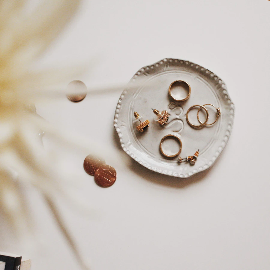 Gold rings and earrings in a ceramic dish