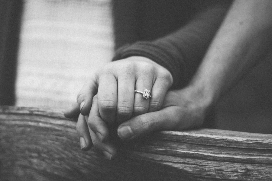Couple holding hands showing an engagement ring