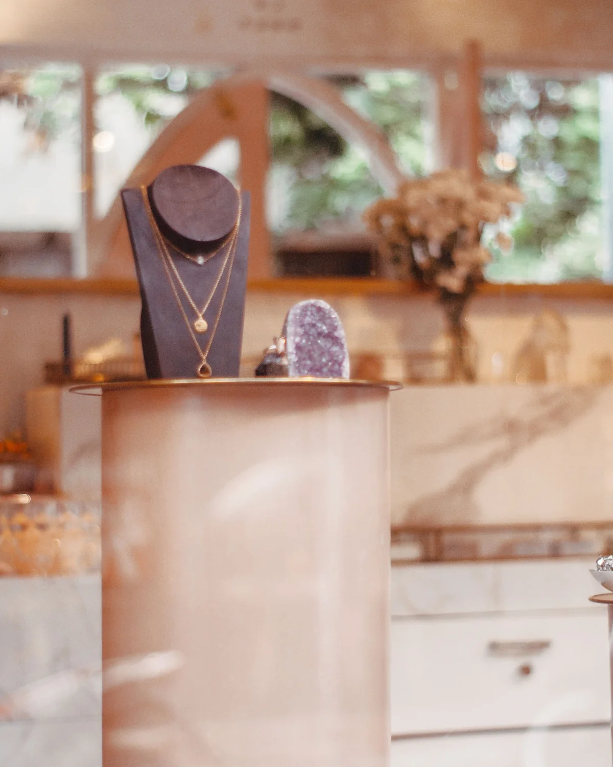 Gold necklaces on a display bust in a softly lit jewelry showroom